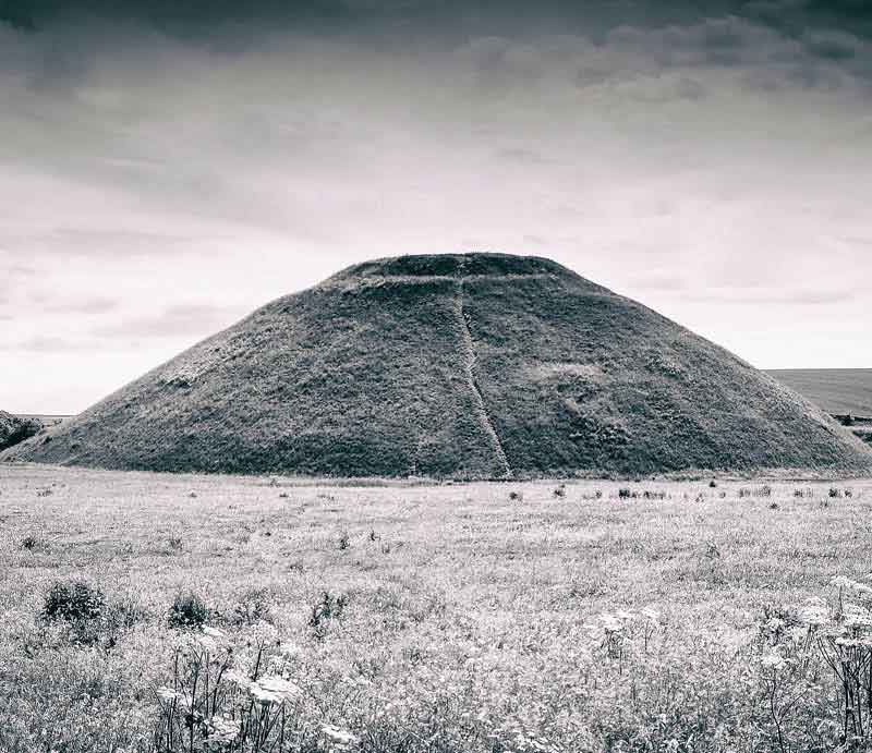 The giant Neolithic mound in the landscape.